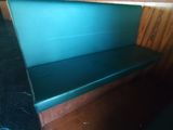 un banc vert avec une assise noire, dans un coin de la pièce