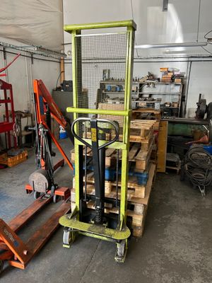 un chariot élévateur dans un entrepôt où se trouvent des palettes de bois