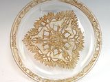 a glass plate with a gold design on it