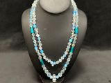 a necklace with blue and white beads on a mannequin