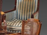 pair of antique carved wood chairs with striped upholstered cushions