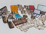 a lot of silverware on a table with a case
