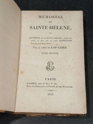 an open book sitting on top of a black table next to a pair of scissors