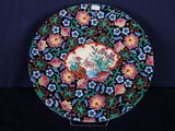 une assiette décorative ornée de fleurs et d'un oiseau