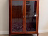 un meuble en bois avec des portes en verre dans le coin d'une pièce