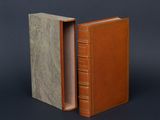 an old book with a leather cover opened to reveal the inside of it