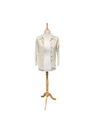 le mannequin tient une chemise blanche posée sur un support en bois