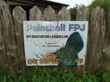 a sign that says paintball py in front of a wooden fence