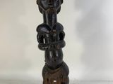 a wooden statue of a man holding a baby