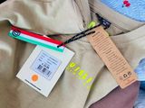 a pile of clothes and a tag on a bed