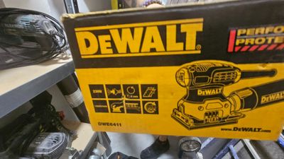 the box is open on the shelf with tools in it