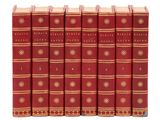 six livres rouges alignés sur une surface blanche