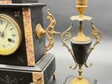 two clocks and a vase sitting on a table