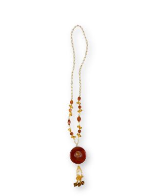 un collier composé d'une perle rouge et d'une chaîne en or