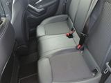 the back seats of a red car with a black seat belt