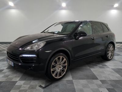 the porsche cayen is parked on a checkered tile floor