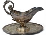 an antique silver plate with a saucer on it on a white background
