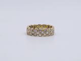 a yellow gold ring with diamonds on a white background