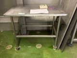 une table en métal sur laquelle se trouve un livre, dans une pièce
