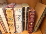 de nombreux livres qui se trouvent sur une étagère dans la pièce