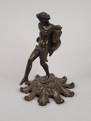 une figurine antique en bronze représentant un homme tenant un éventail