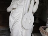 a statue of a woman holding a guitar and a bowl of donuts