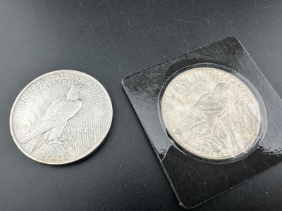 un gros plan d'une pièce de monnaie et d'une petite pièce posées sur une surface noire
