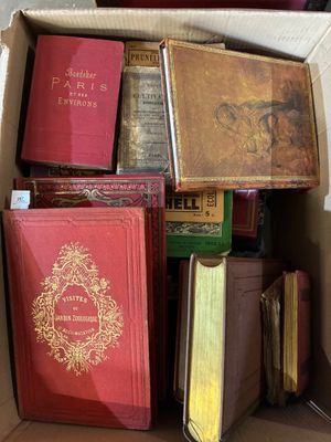 une boîte remplie de livres posés sur le sol
