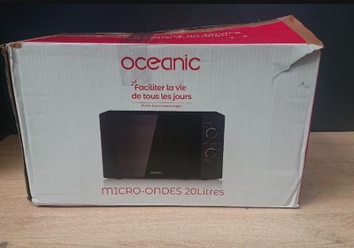 emballage d'un micro-ondes posé sur une table à côté d'une boîte