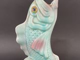 two figurines of a fish on a black background