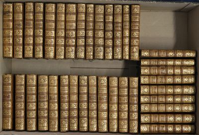 une boîte ouverte remplie de nombreux livres, posée sur une table