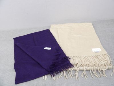 purple and cream scarfs with fringes on a bed