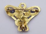 a close up of a brooch with a butterfly on it
