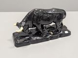 statue of a bull on a rock on a white surface