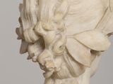 a close up of a statue of a woman with a flower in her hair
