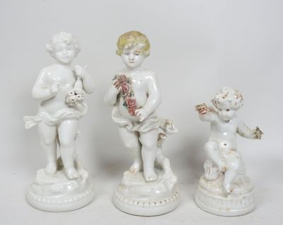 trois figurines blanches représentant des enfants, ornées de fleurs