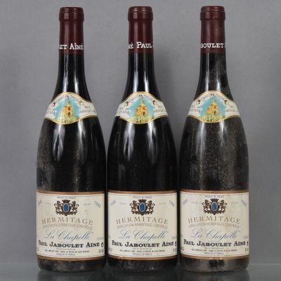 three bottles of wine are lined up on a table