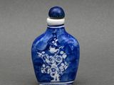 un petit vase bleu et blanc orné de fleurs