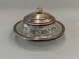 a silver plate with a silver lid on a white table