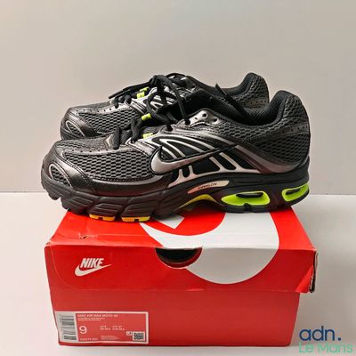 a pair of black and yellow shoes on top of a box
