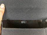 the inside of a black purse with a hand holding it