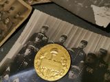 a gold coin sitting on top of a pile of old photos
