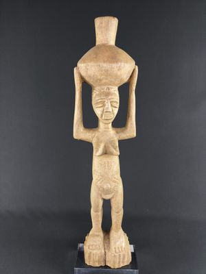 a statue of a woman holding a pot on her head