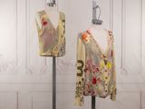 pair of mannequins in front of a white wall with floral designs