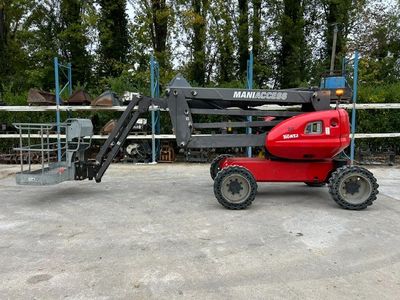 a small red tractor parked in front of a fence
