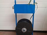 un chariot bleu équipé d'un tuyau, devant une porte de garage