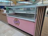 une vitrine rose sur laquelle sont disposés des beignets, dans un immeuble