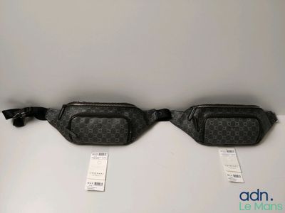 two black and white fanny bags sitting on top of a table