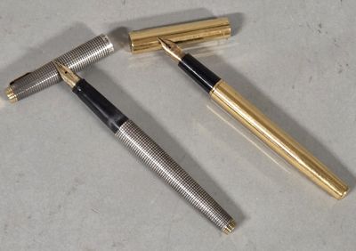 two pens sitting next to each other on top of a table