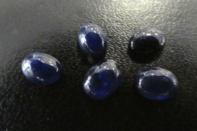 un gros plan sur un groupe de pierres bleues posées sur une surface noire